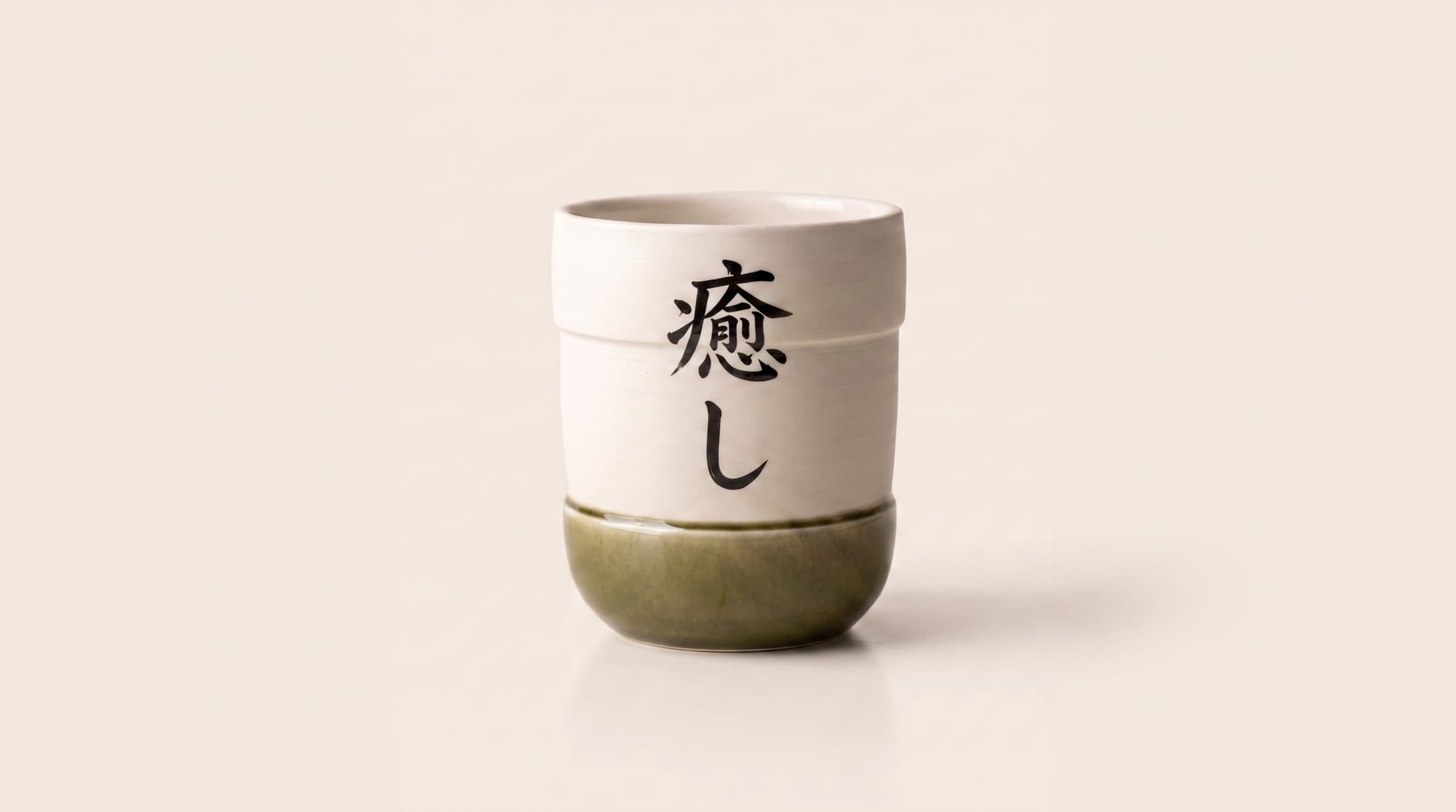 The finished Luvano cup — moss-green glaze, hand-brushed and lettered